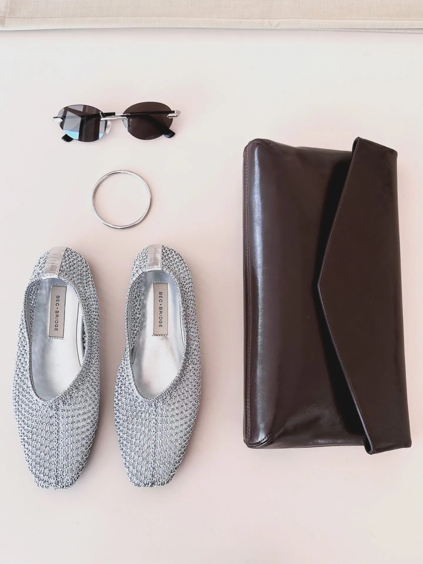 Flat lay of Miami Vice style accessories including sunglasses and loafers