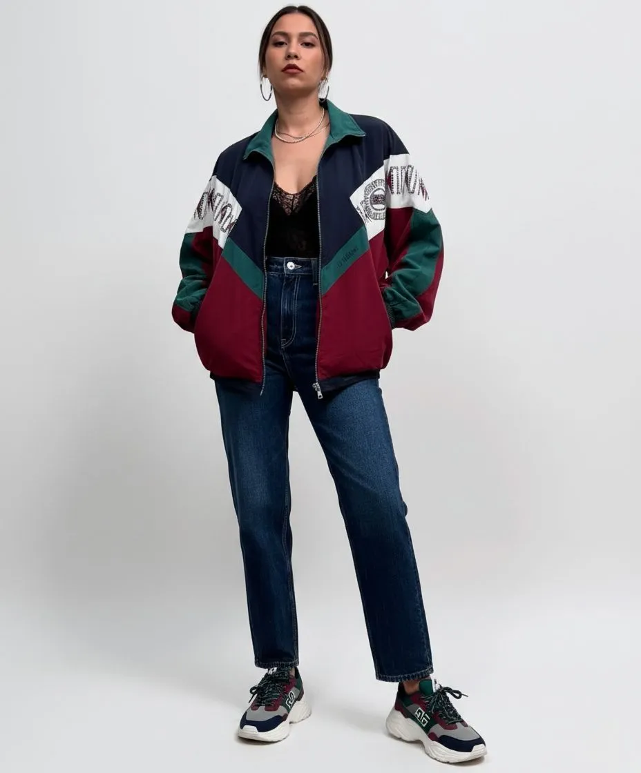 Woman wearing oversized teal and magenta color-block windbreaker for 80s themed cruise party