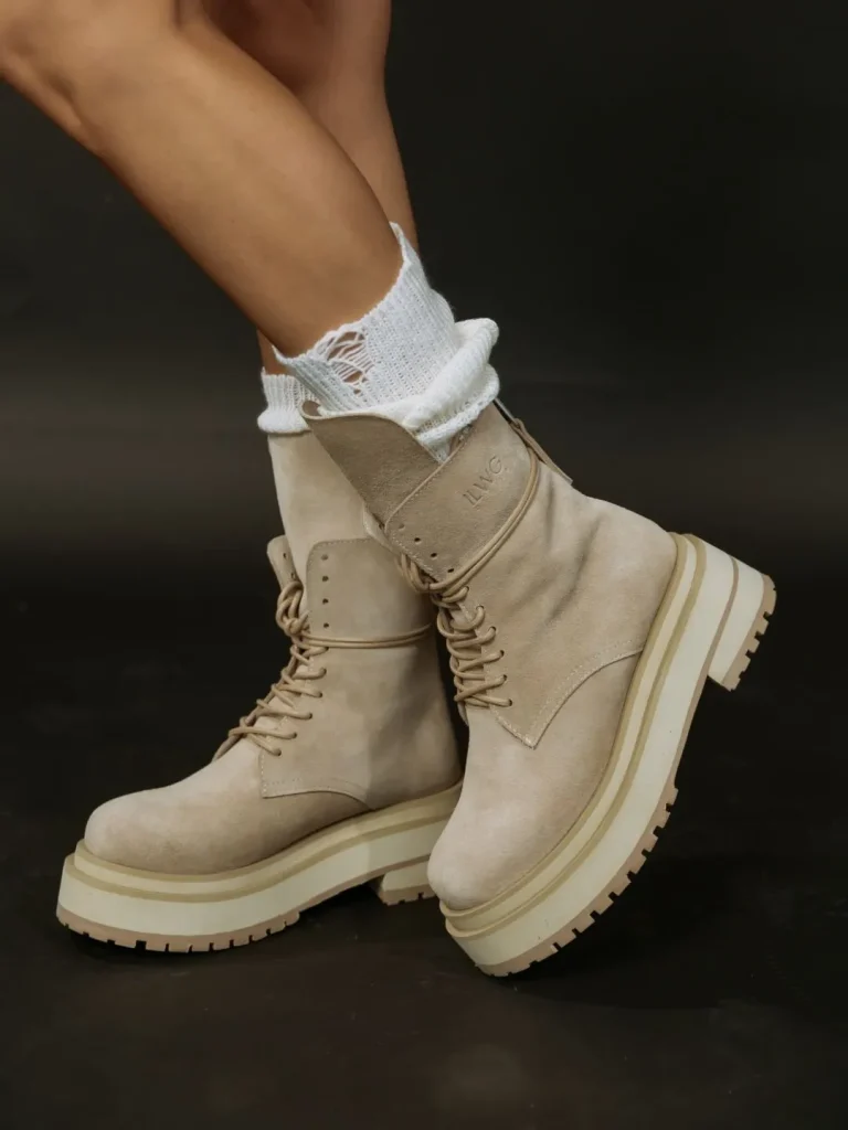 Beige suede hiking boots with red laces styled with linen trousers