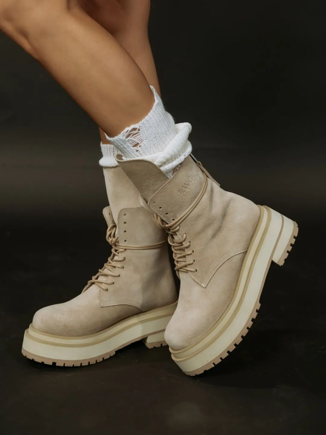 Beige suede hiking boots with red laces styled with linen trousers