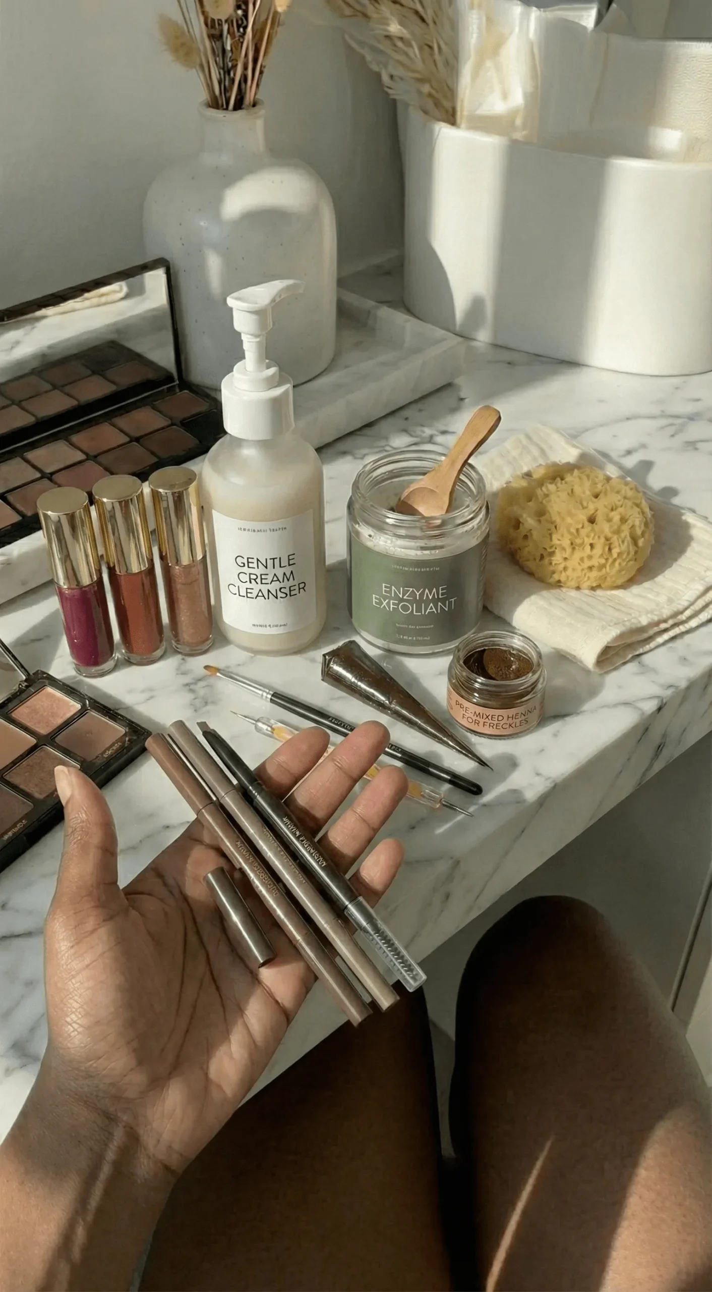 Flat lay of eyebrow pencils and henna for faux freckles