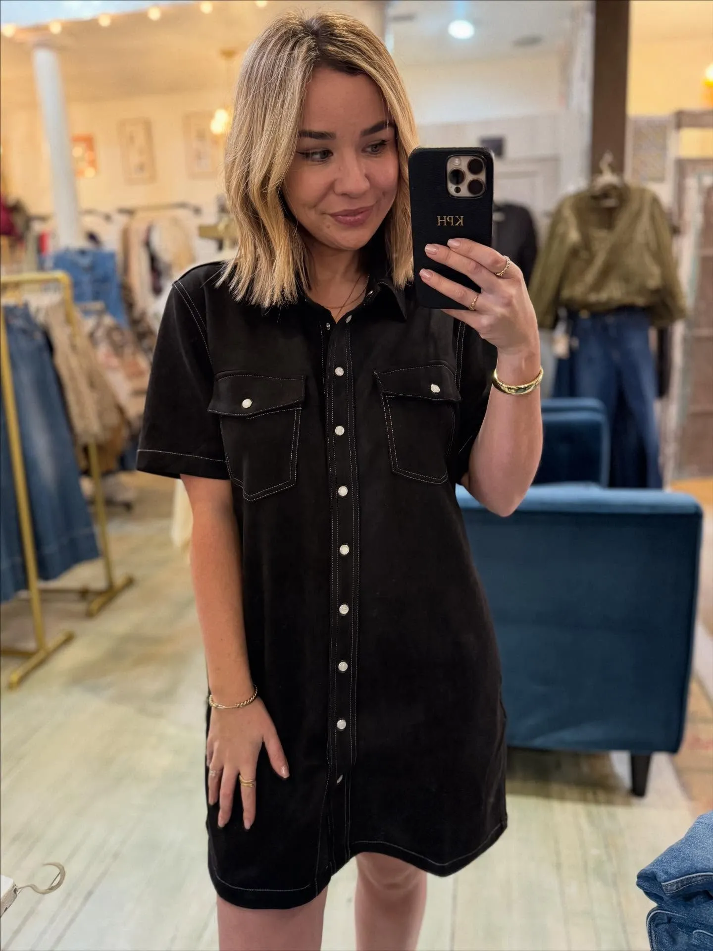 Woman wearing a fitted black suede western shirt dress with silver details for an evening event