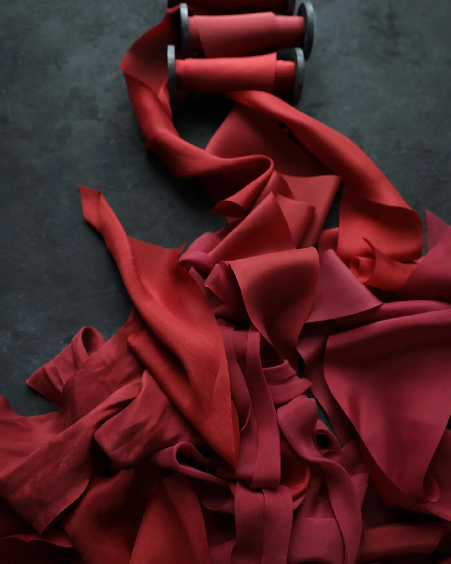 Close up of crimson, oxblood, and maroon silk fabric textures