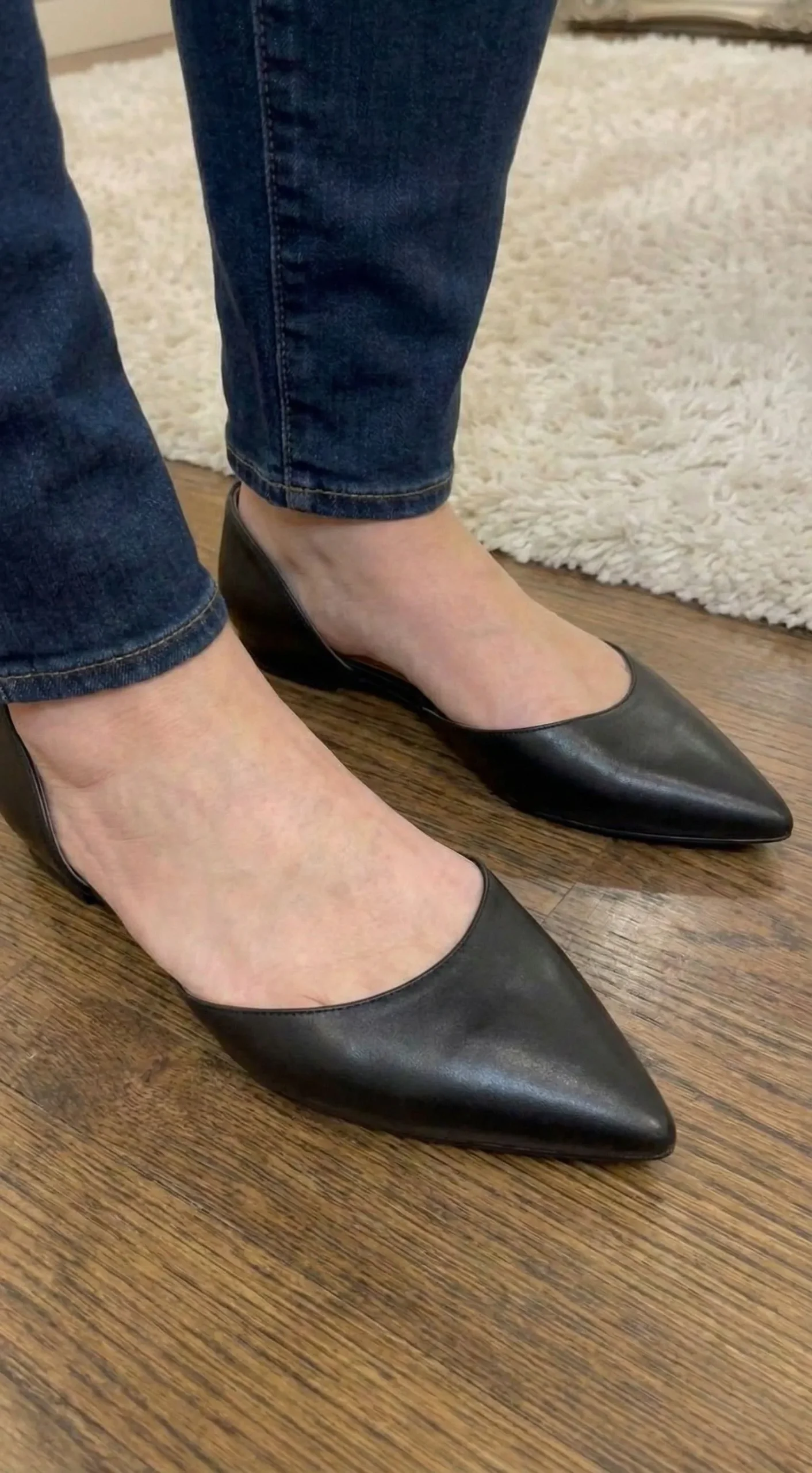 Plus size fashion model wearing black pointed toe flats with jeans