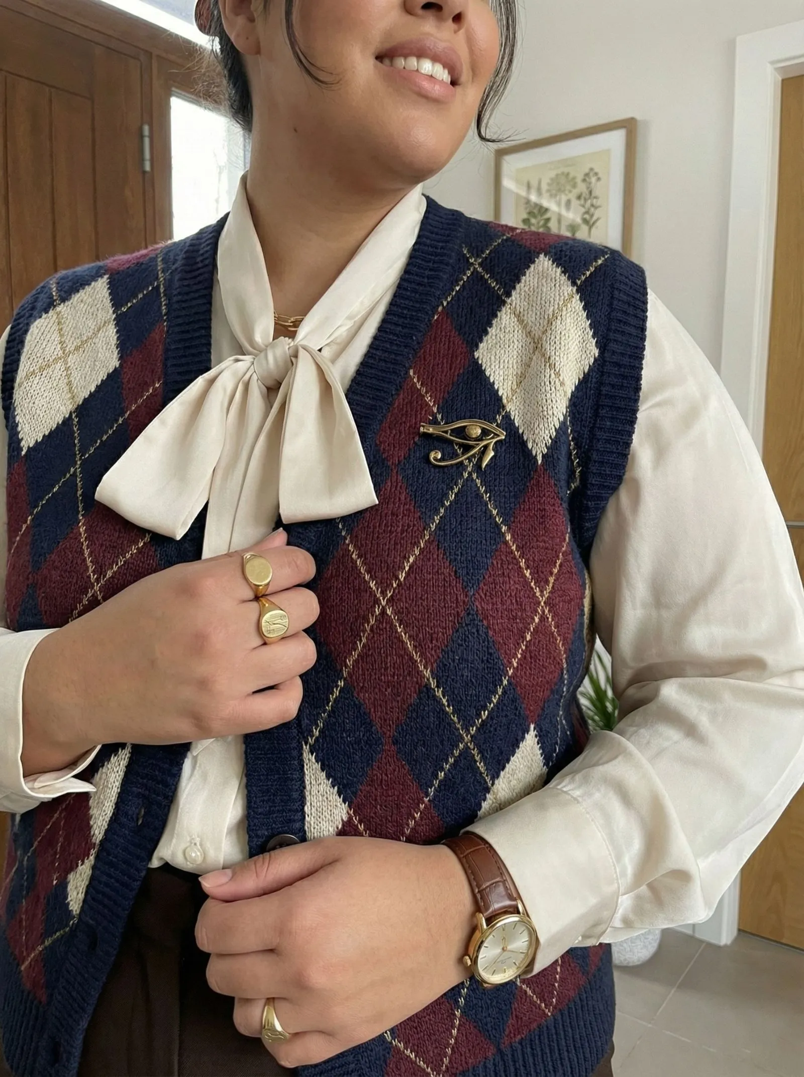 Close up of an argyle knit vest layered over a white shirt.