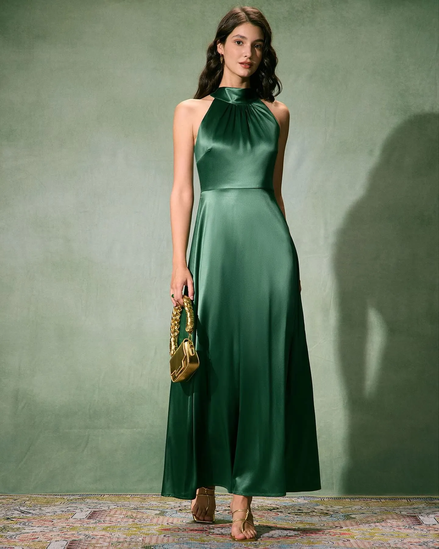 Woman wearing modest emerald green satin high neck maxi dress at candlelit dinner