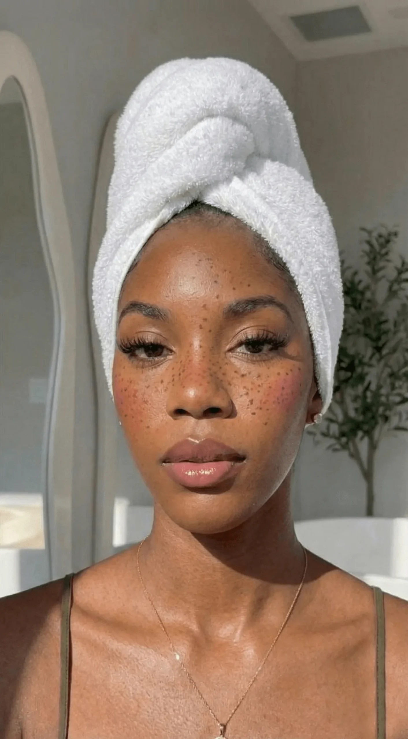 Close up of deep skin tone with dewy faux freckles makeup