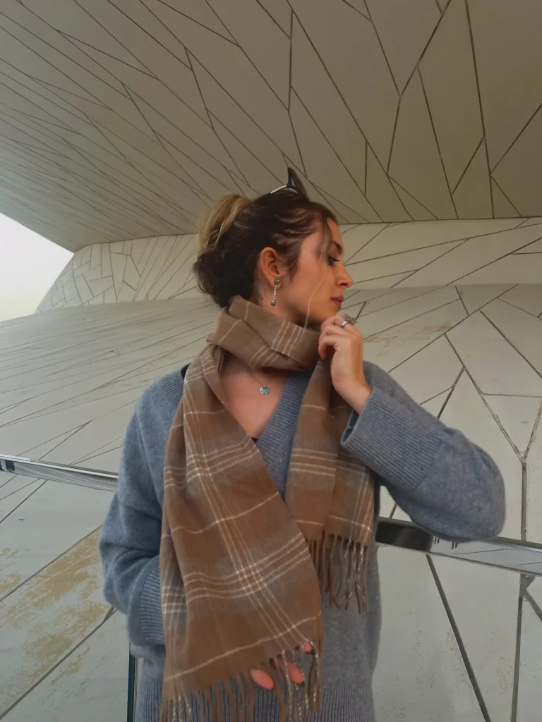 Grey cashmere scarf draped over silk blouse