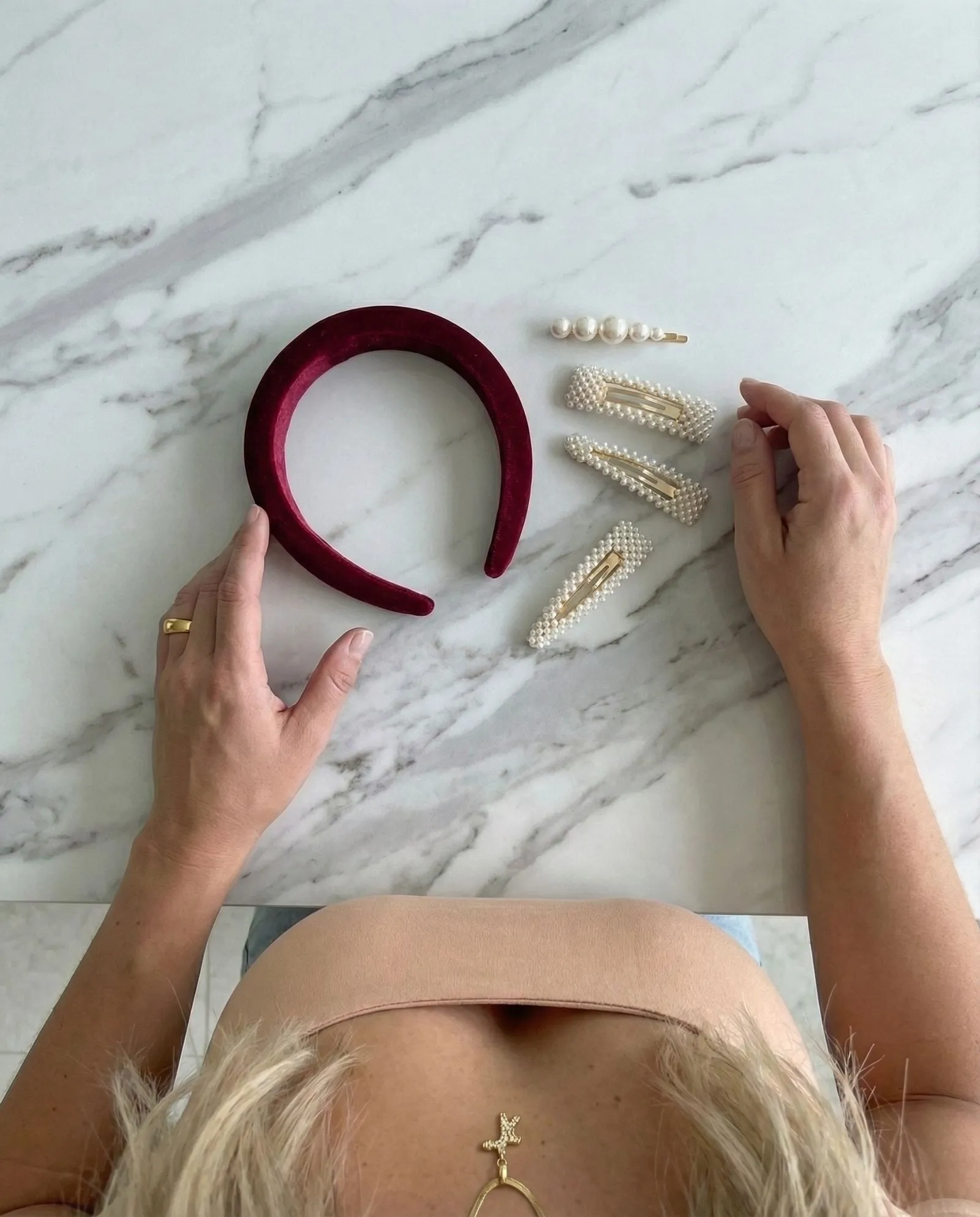 Flat lay of velvet headbands and pearl hair clips on marble