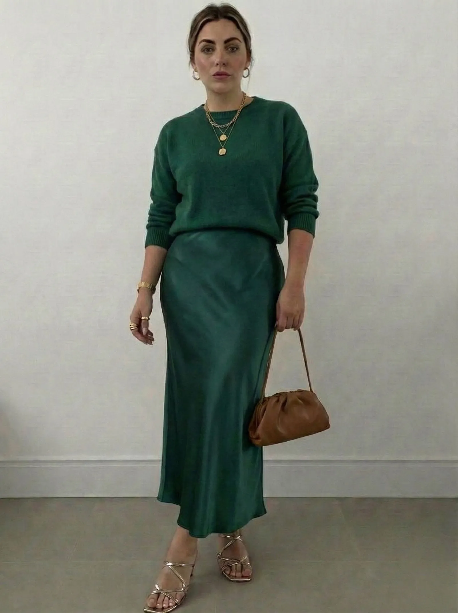 Hourglass figure styling a monochromatic green outfit with satin skirt and knit top