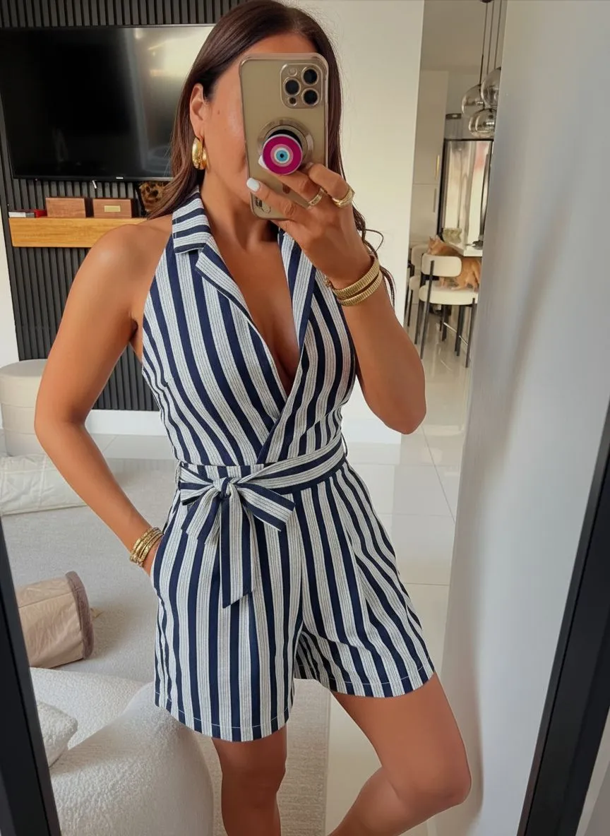 Curvy petite woman wearing a navy and white striped jumpsuit with a belted waist