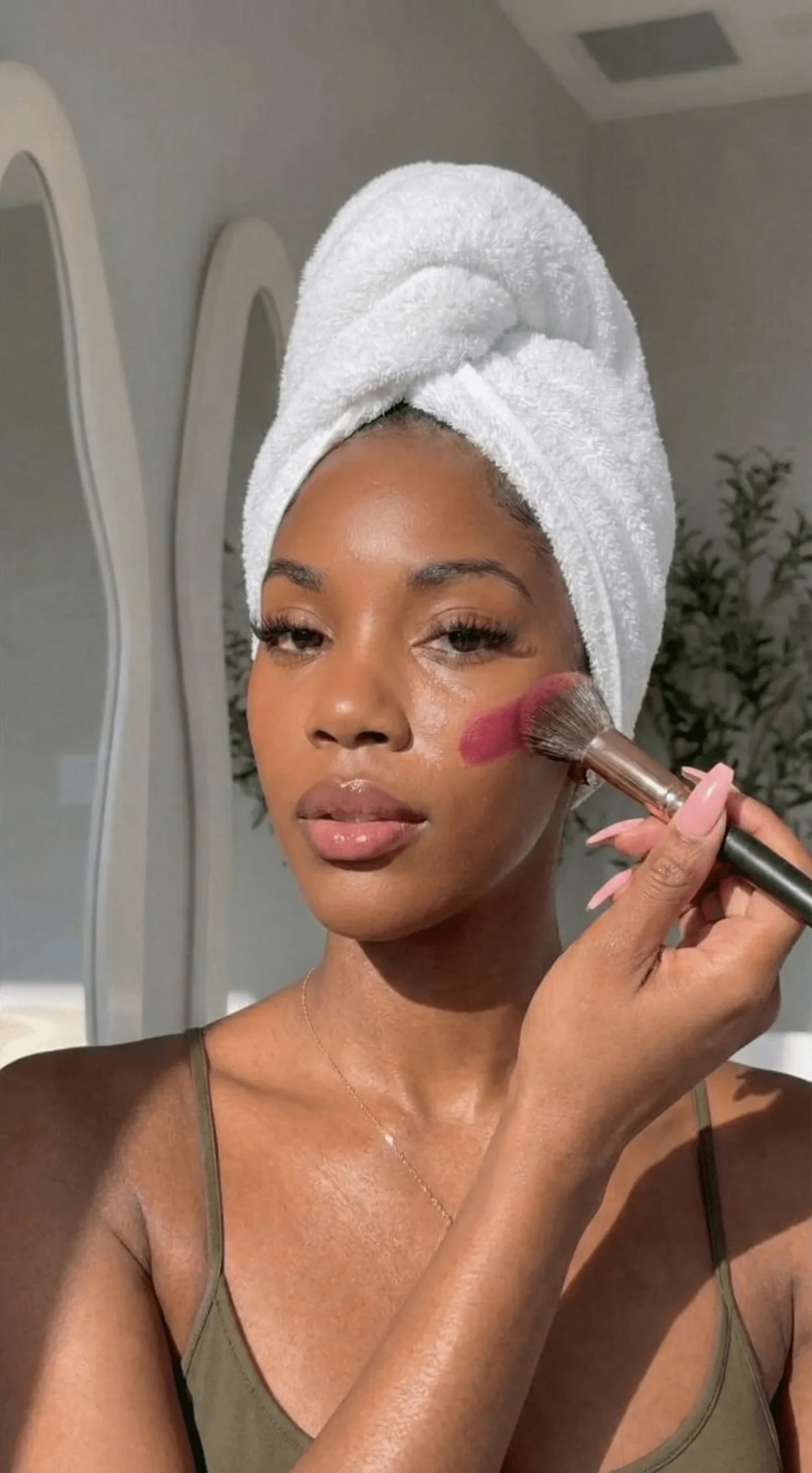 Model with dark skin testing plum cream blush for a natural glow