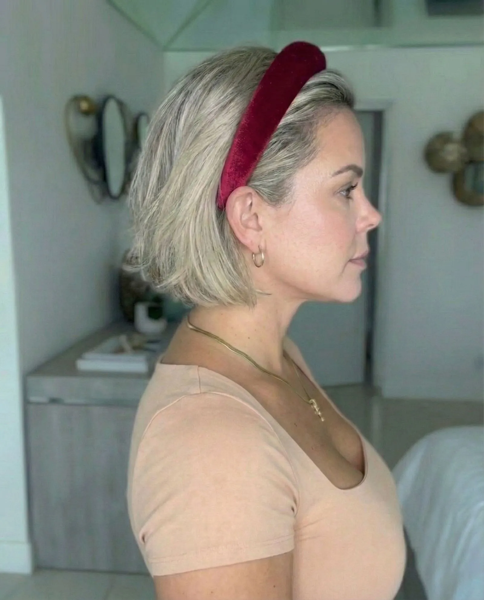 Woman wearing a crimson velvet padded headband to style a bob