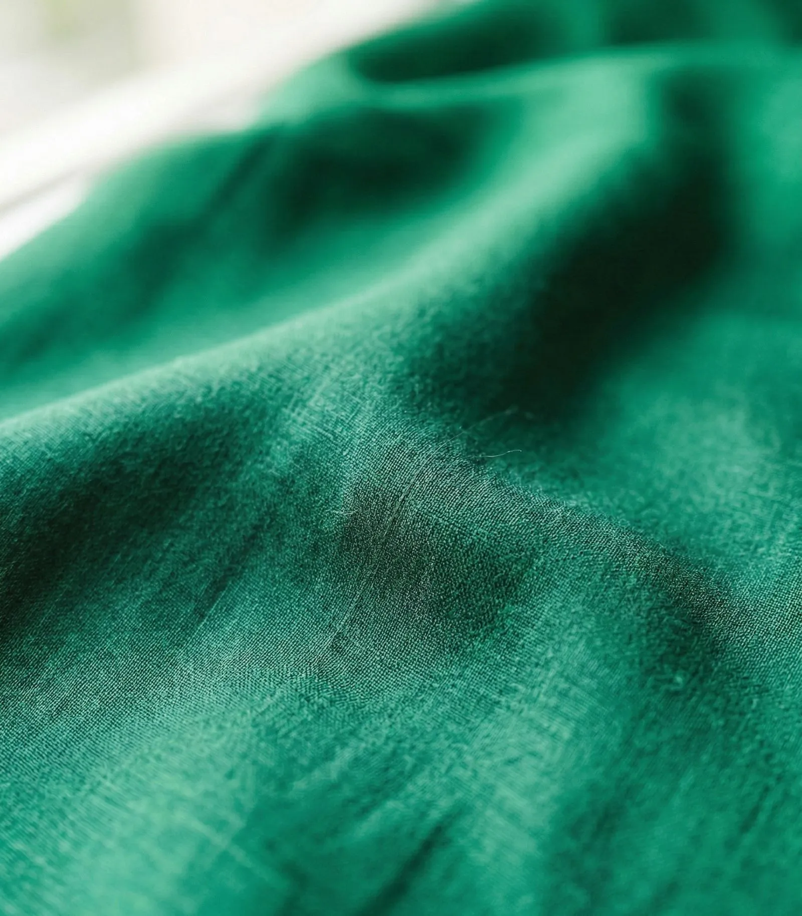 Close-up of emerald green bamboo viscose fabric texture for cooling summer workwear