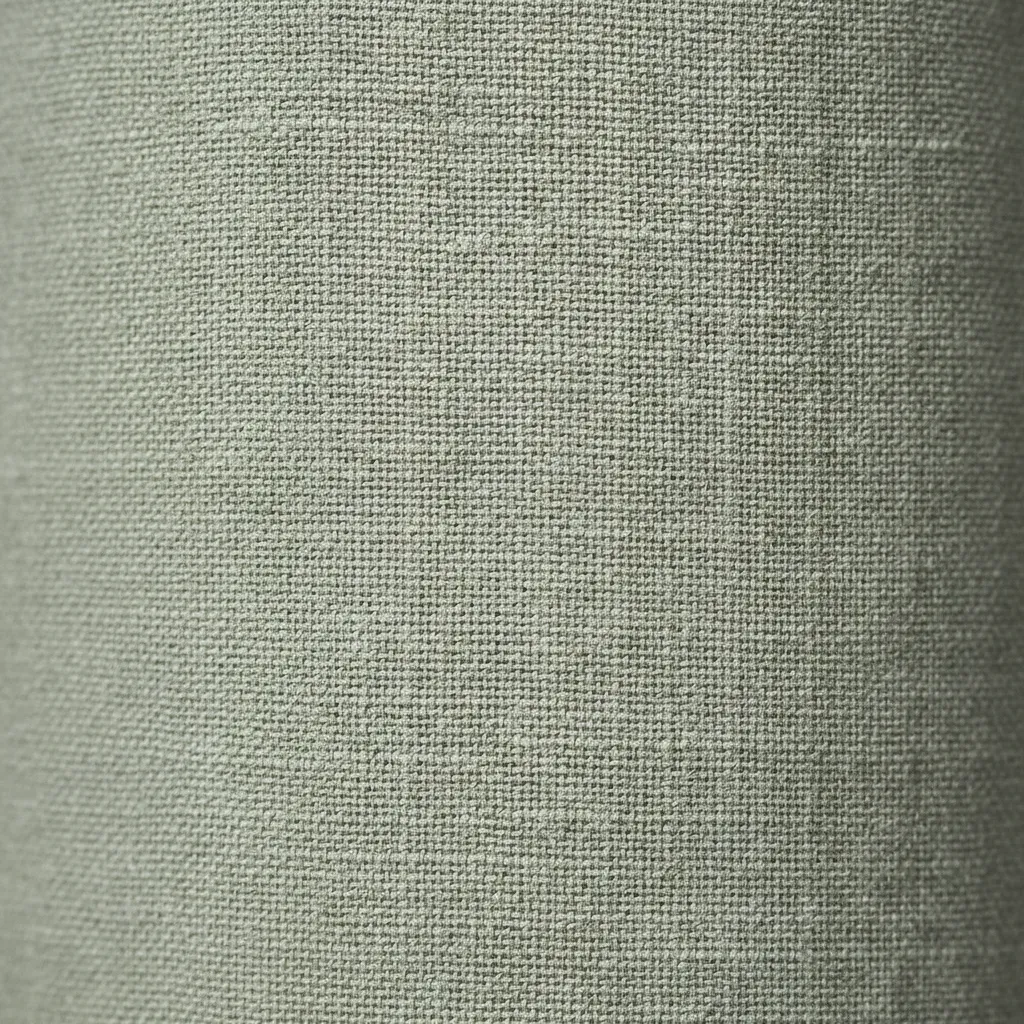 Macro detail of sage green linen fabric showing breathable weave for summer clothing