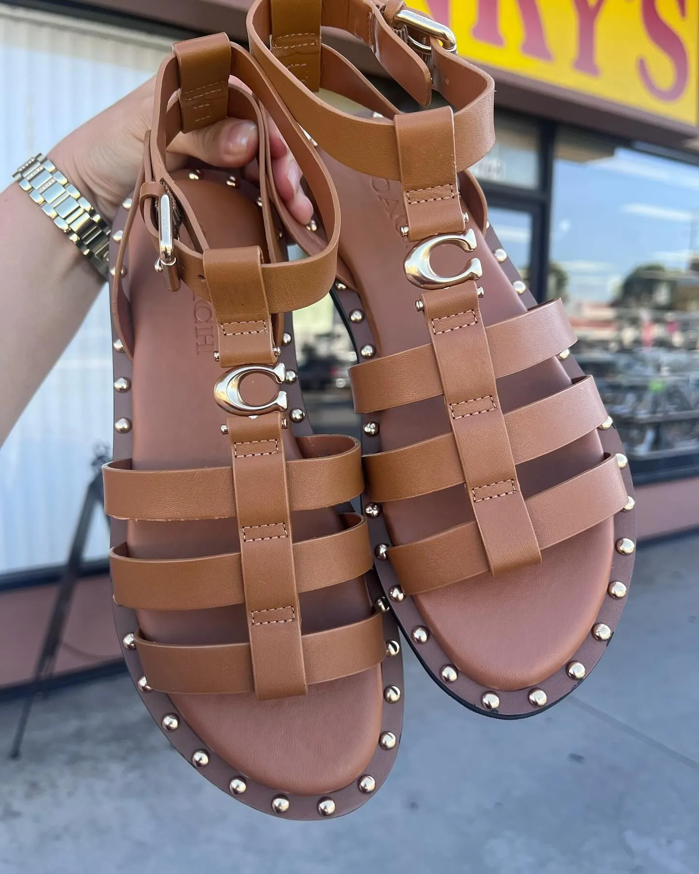 Cognac leather gladiator sandals on sand
