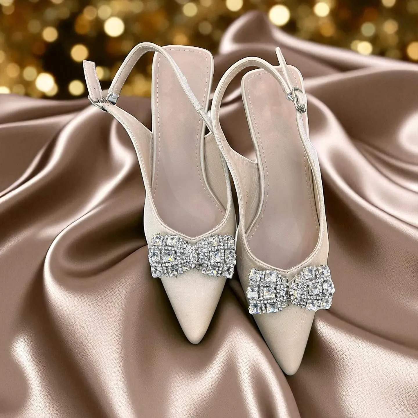 White kitten heels and pearl headband accessories on marble surface