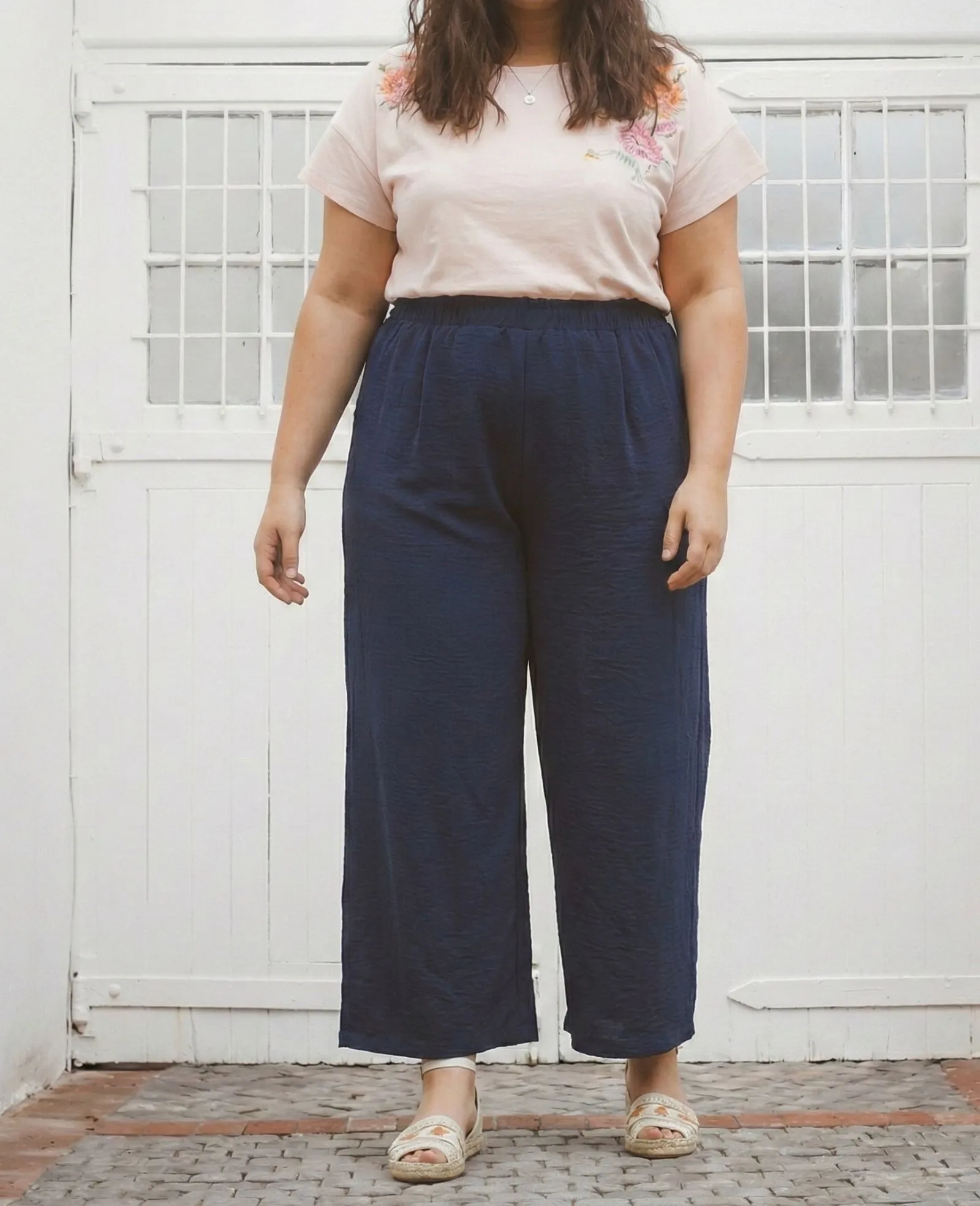 Close up of navy blue matte crepe fabric texture on wide leg trousers