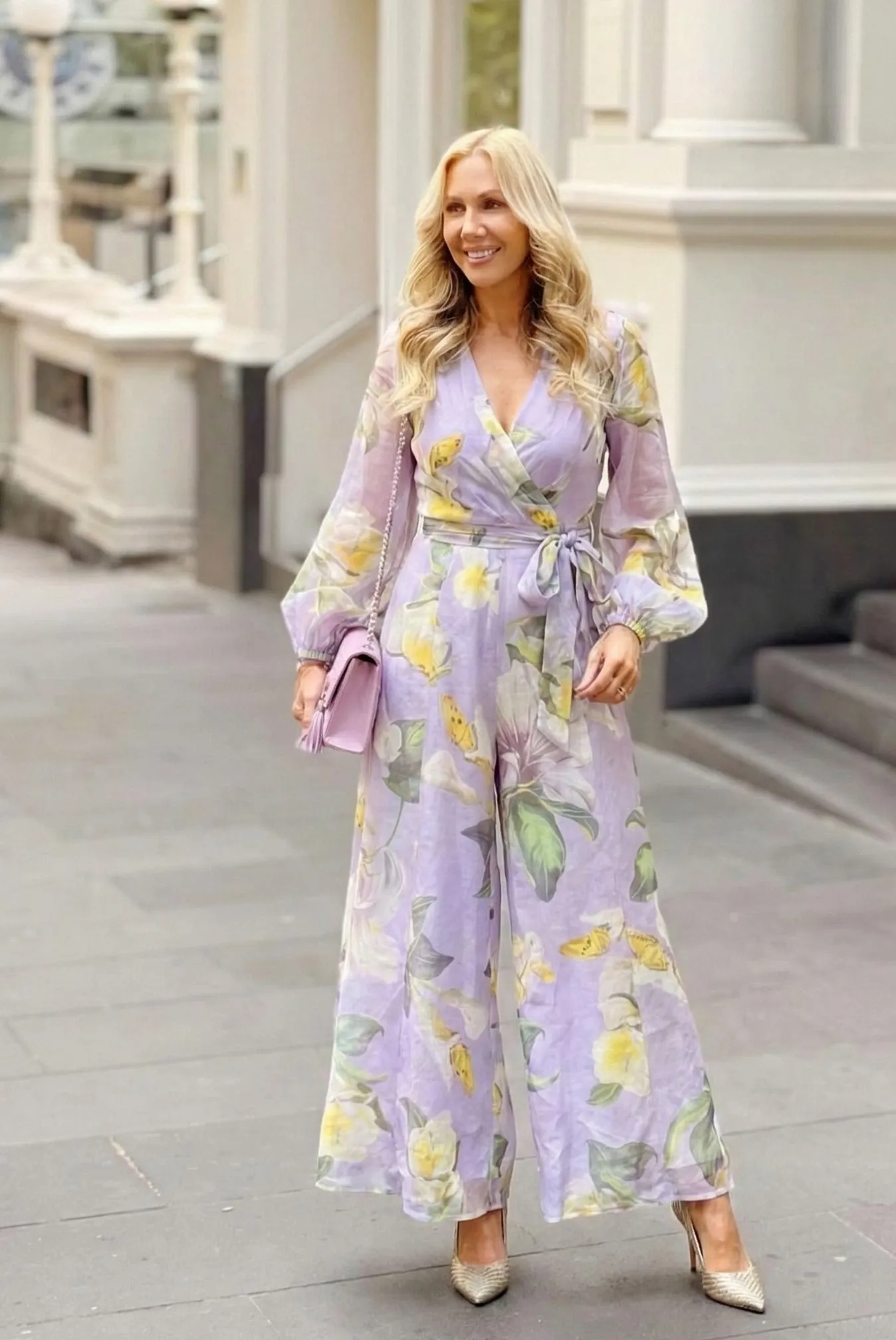 Woman wearing a lavender chiffon floral wrap jumpsuit suitable for church services