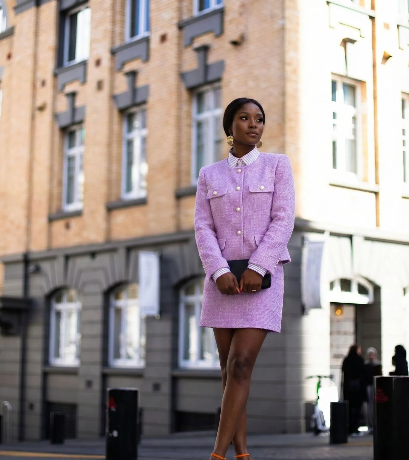 Black woman wearing elegant lilac tweed suit with pearl buttons for Easter church service