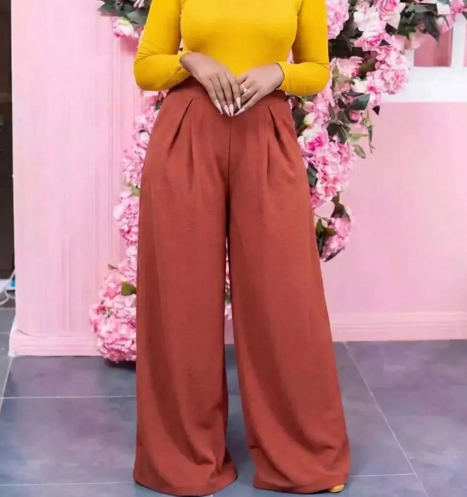 Plus size woman wearing terracotta matte crepe wide leg trousers in an office setting