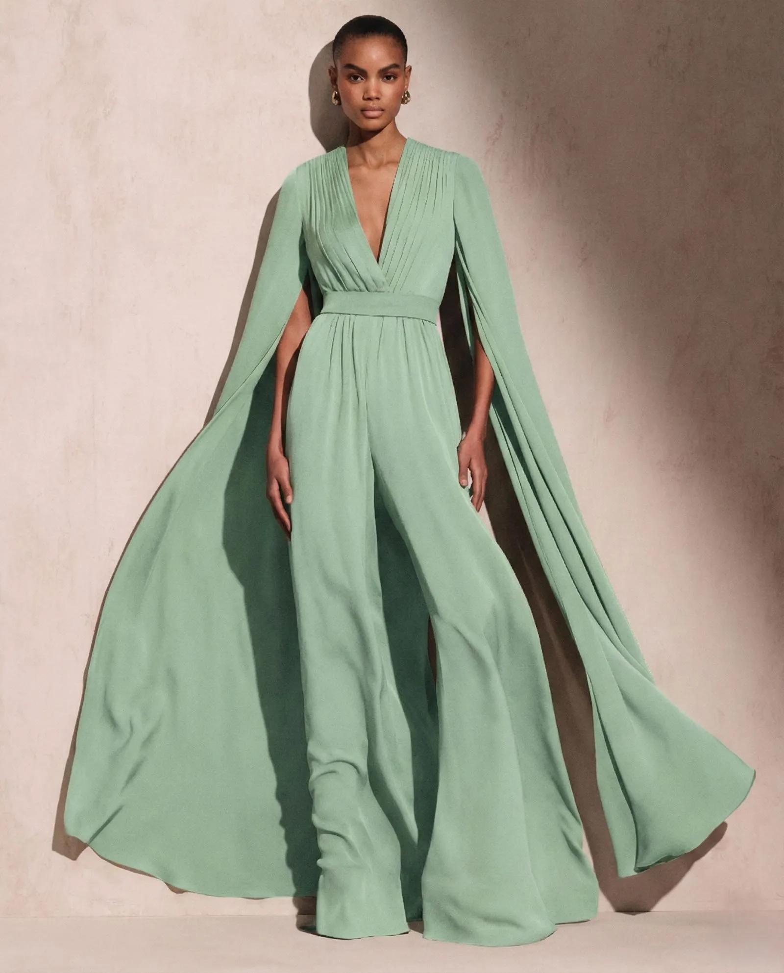 Woman wearing a modest mint green cape sleeve jumpsuit suitable for Easter church service