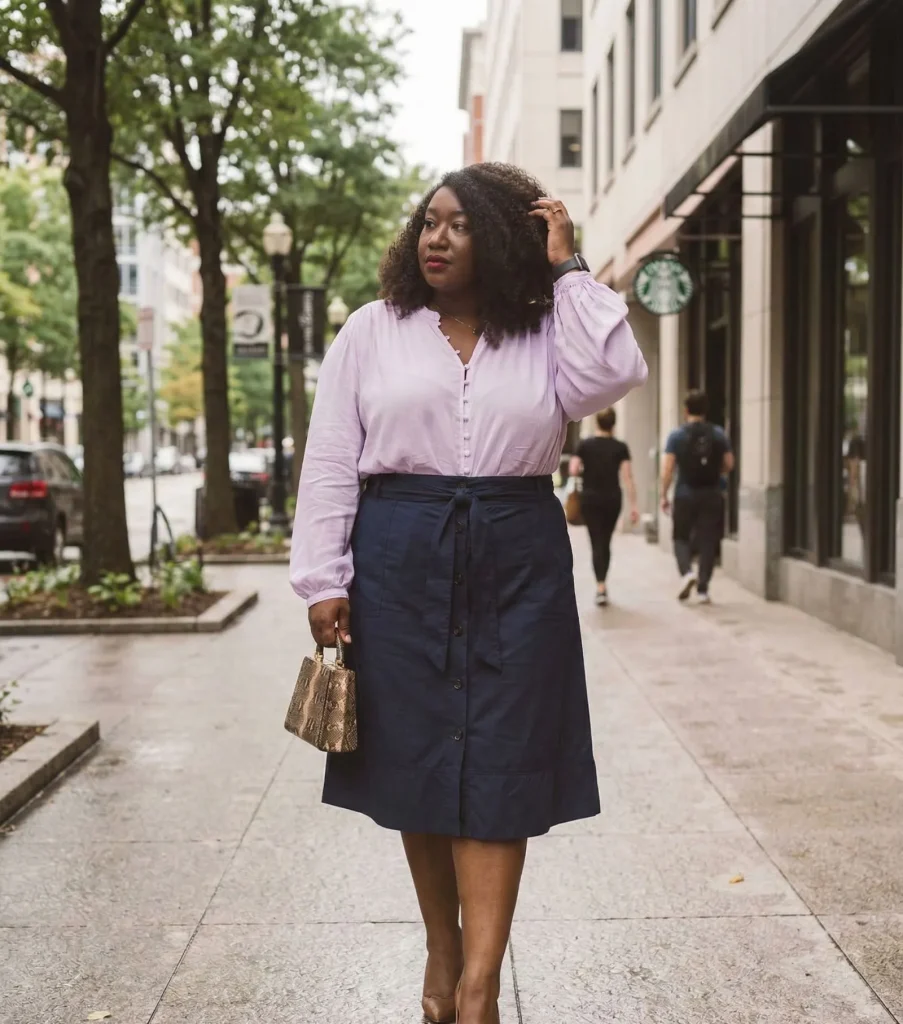 Plus size woman wearing lavender bamboo blouse and navy A-line skirt for humid weather workwear