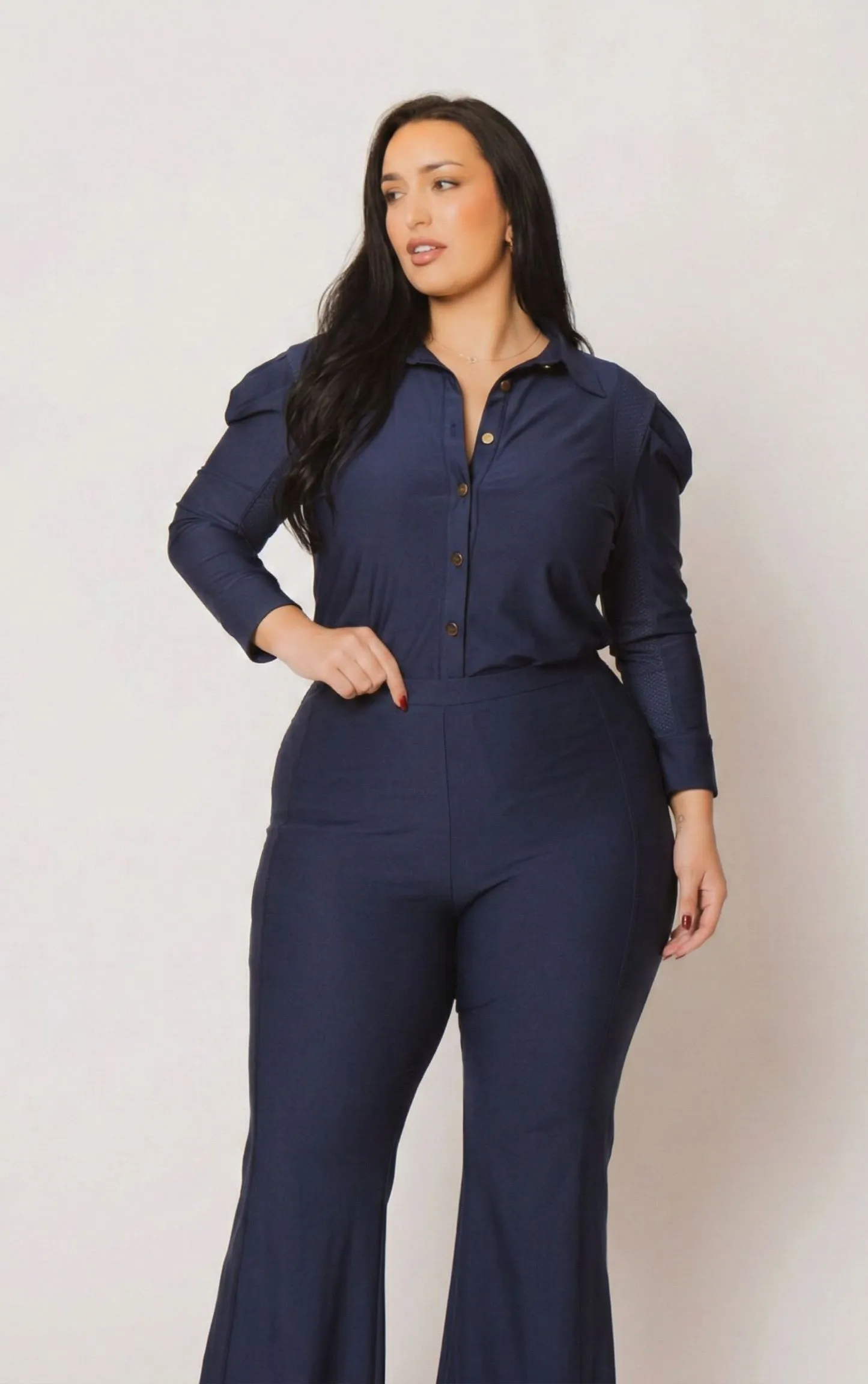 Plus size woman wearing a moisture-wicking navy jumpsuit in a business casual office setting