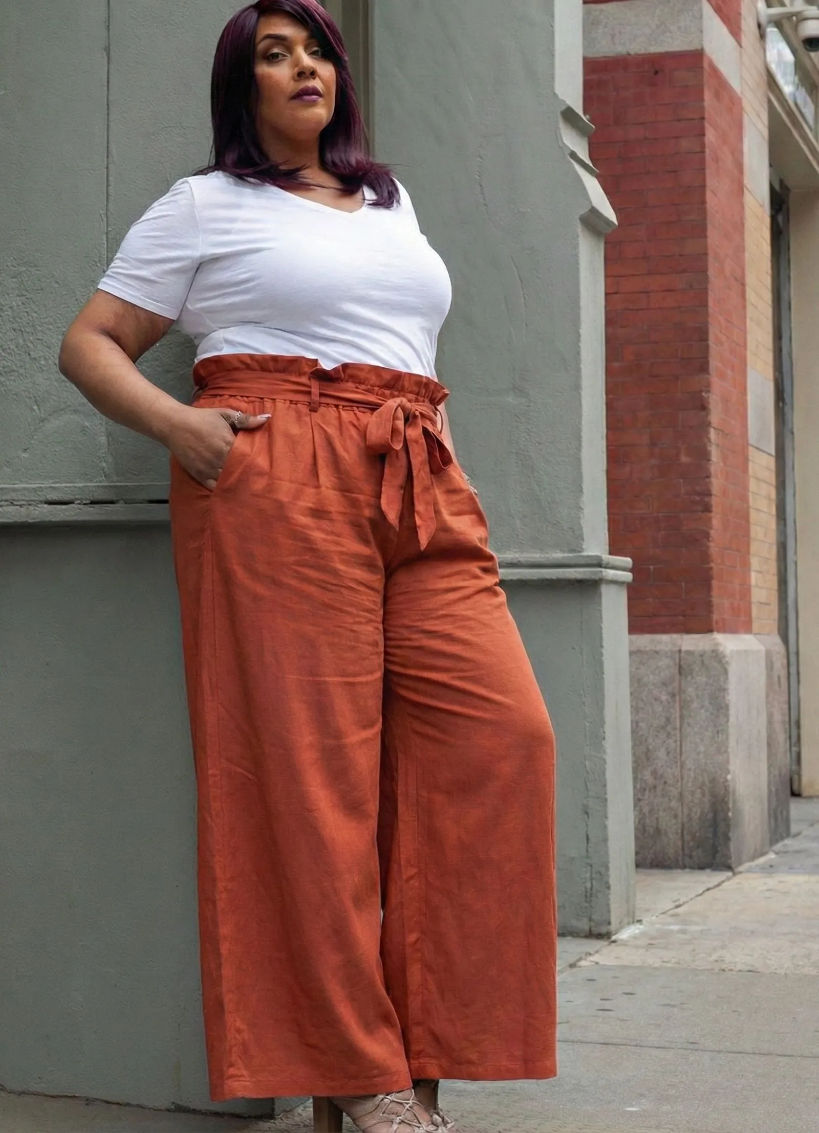 Plus size professional wearing burnt orange breathable wide-leg trousers with paperbag waist in office