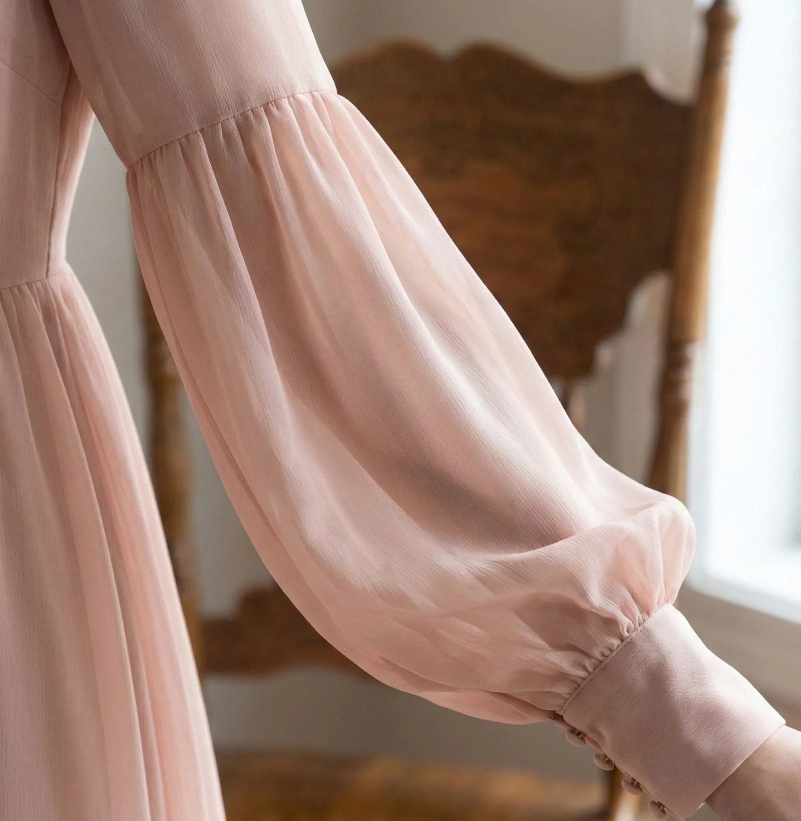 Close up of modest sheer bishop sleeves on a pink chiffon dress