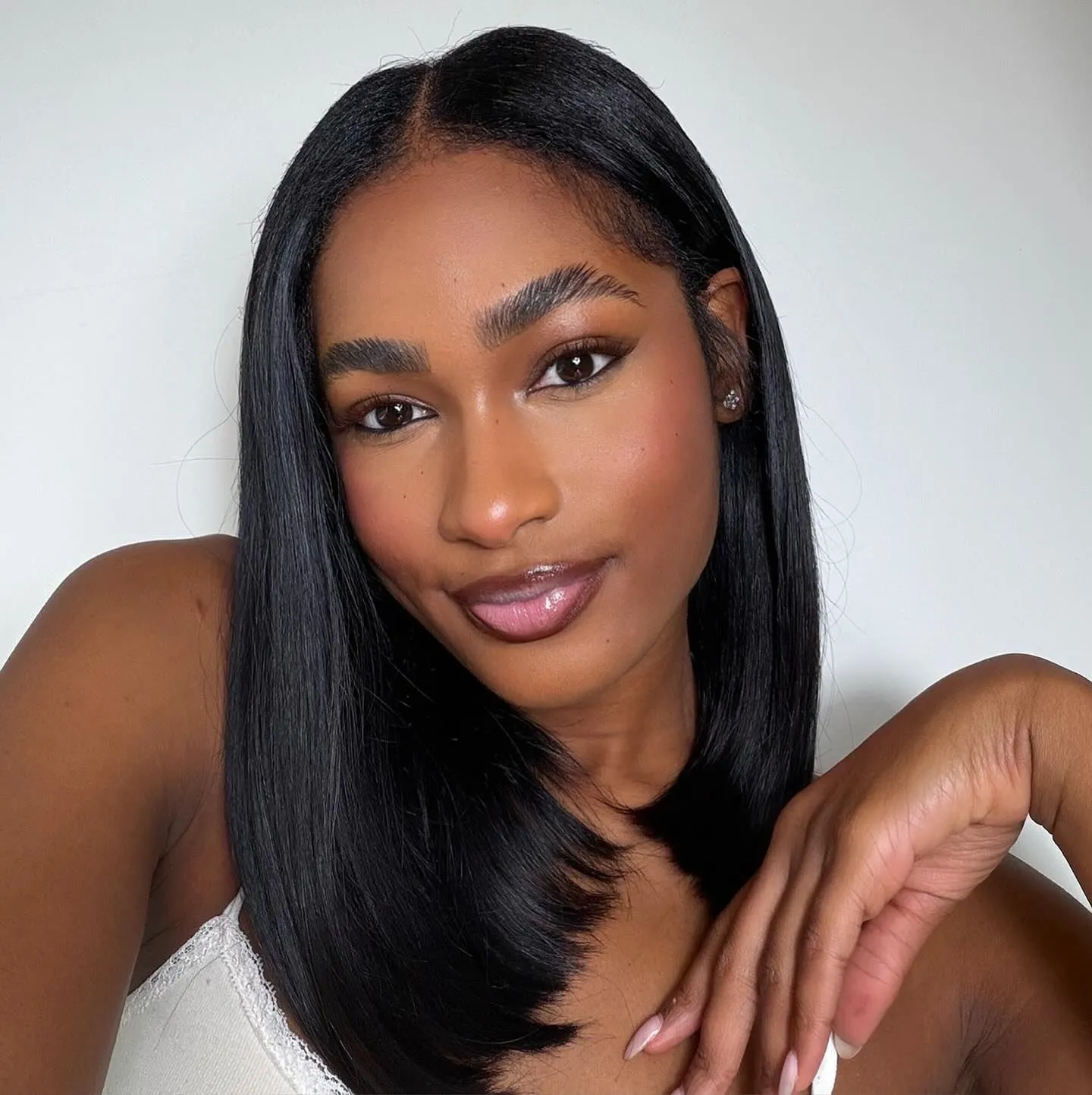 Black woman with glowy makeup and lavender eyeshadow looking elegant