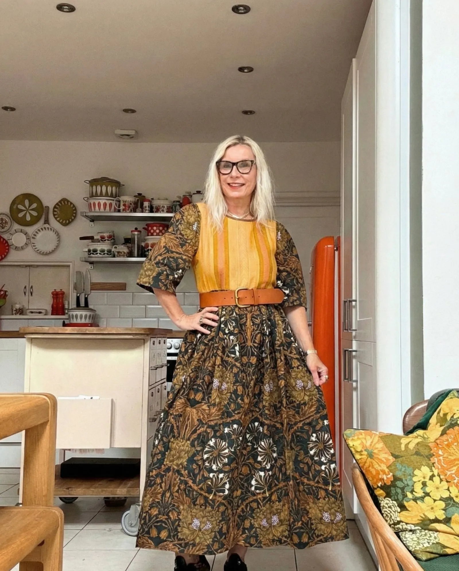 Detail of floral shirt dress cinched with a tan leather belt