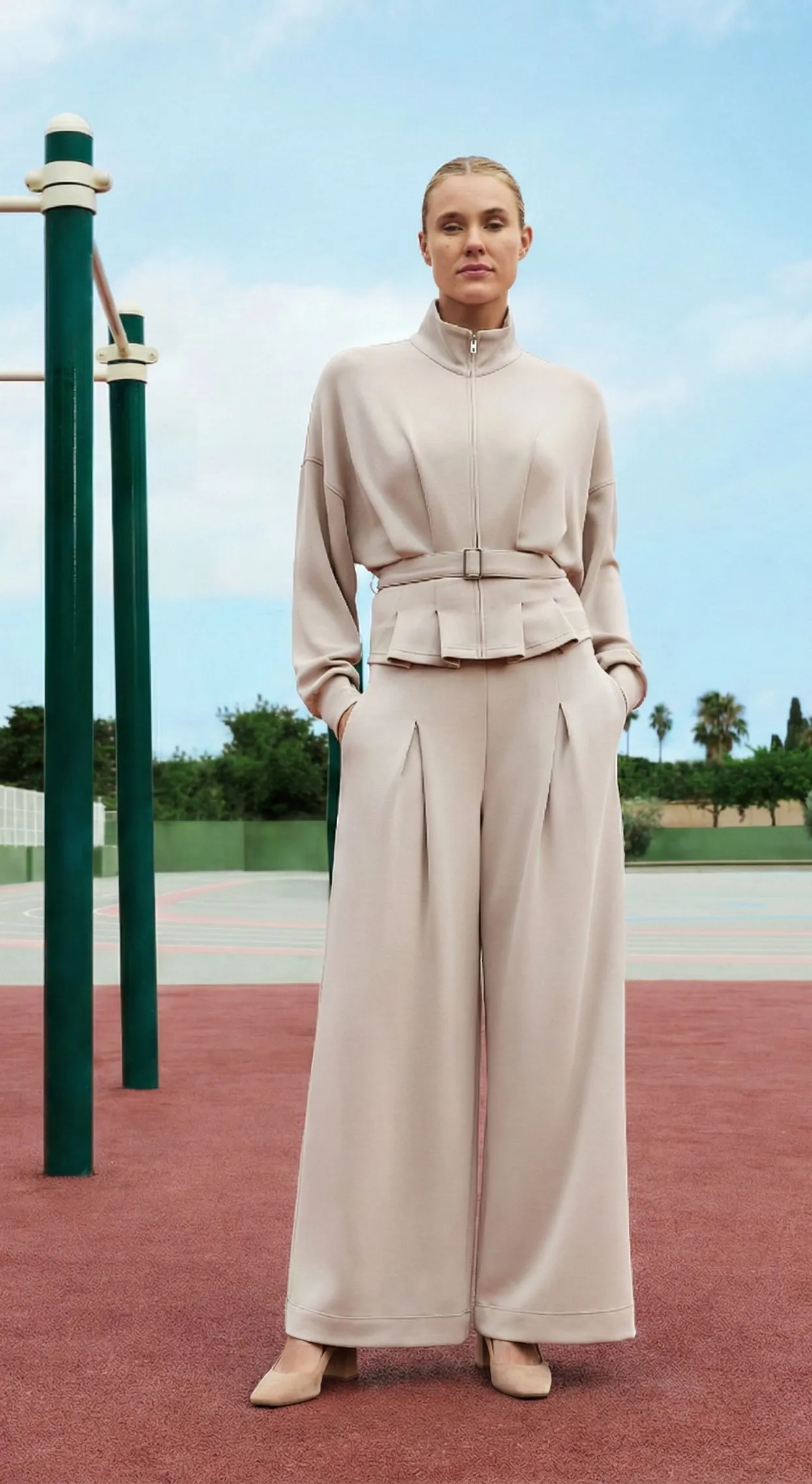 Stylish woman wearing beige culotte jumpsuit with nude block heels