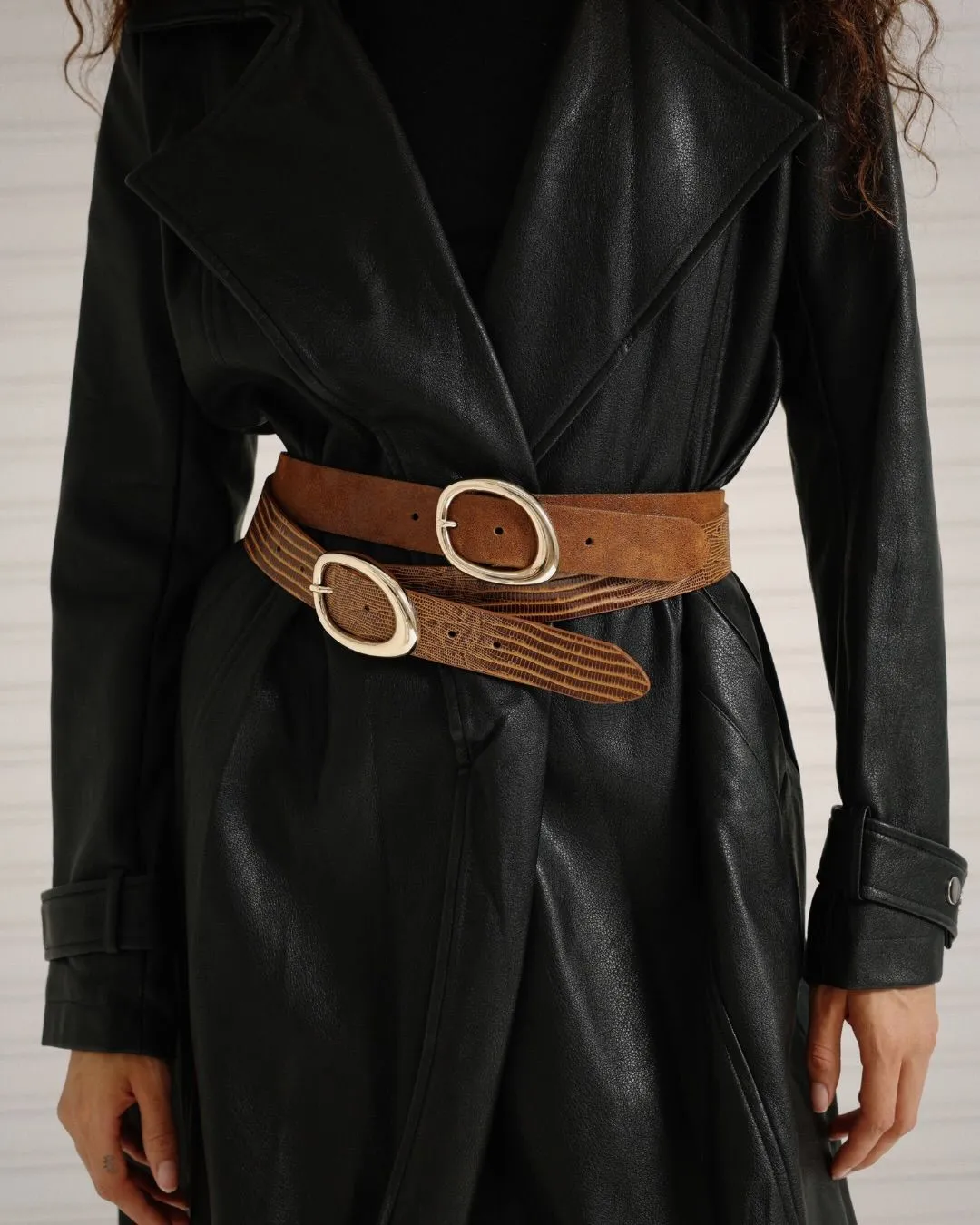Close-up of a leather belt styled over a floral tiered dress