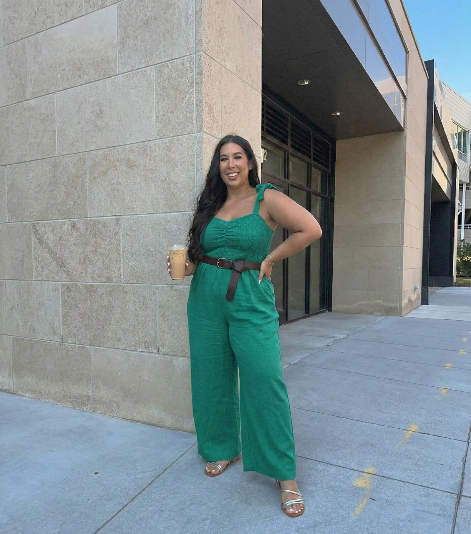 Plus size fashion model wearing a belted green wide-leg jumpsuit