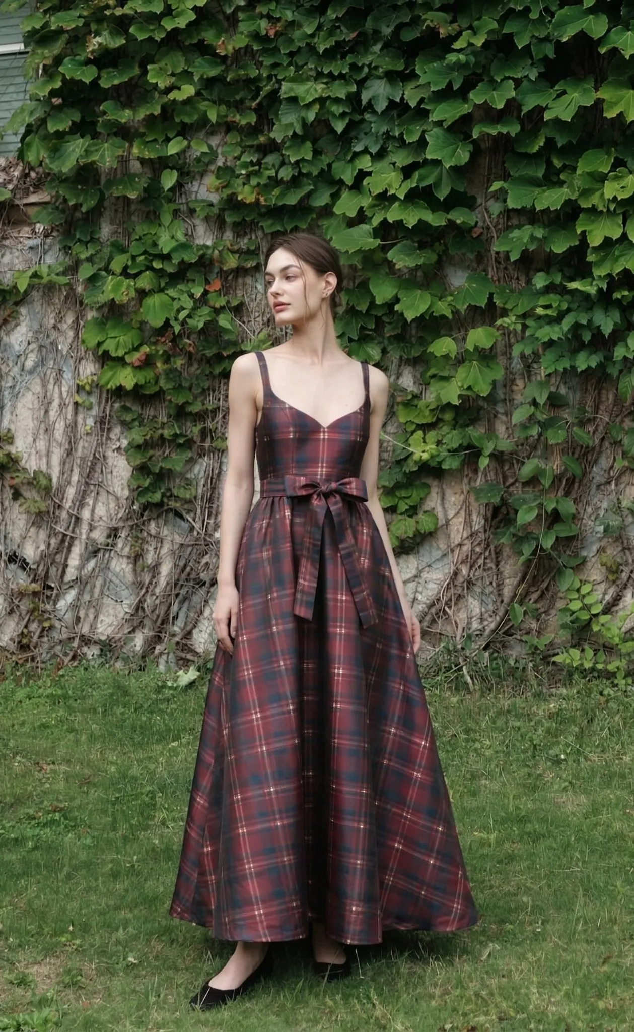 A beautiful woman with an hourglass figure wearing a red plaid fit-and-flare western maxi dress with a waist tie.