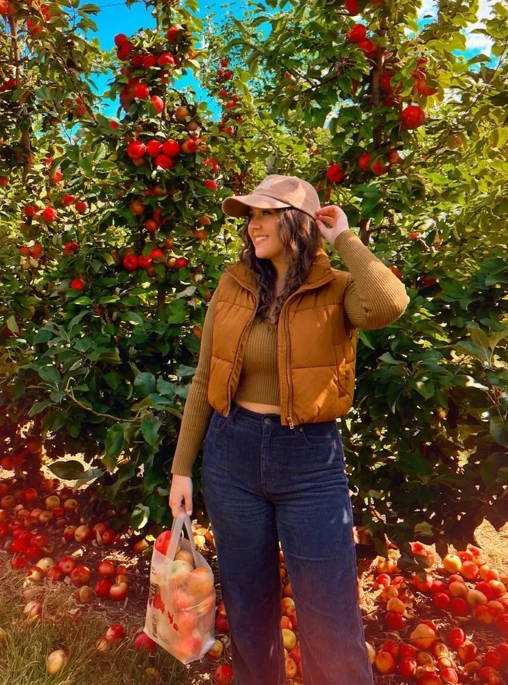 Curvy woman styling a cropped puffer vest and high waisted corduroy pants