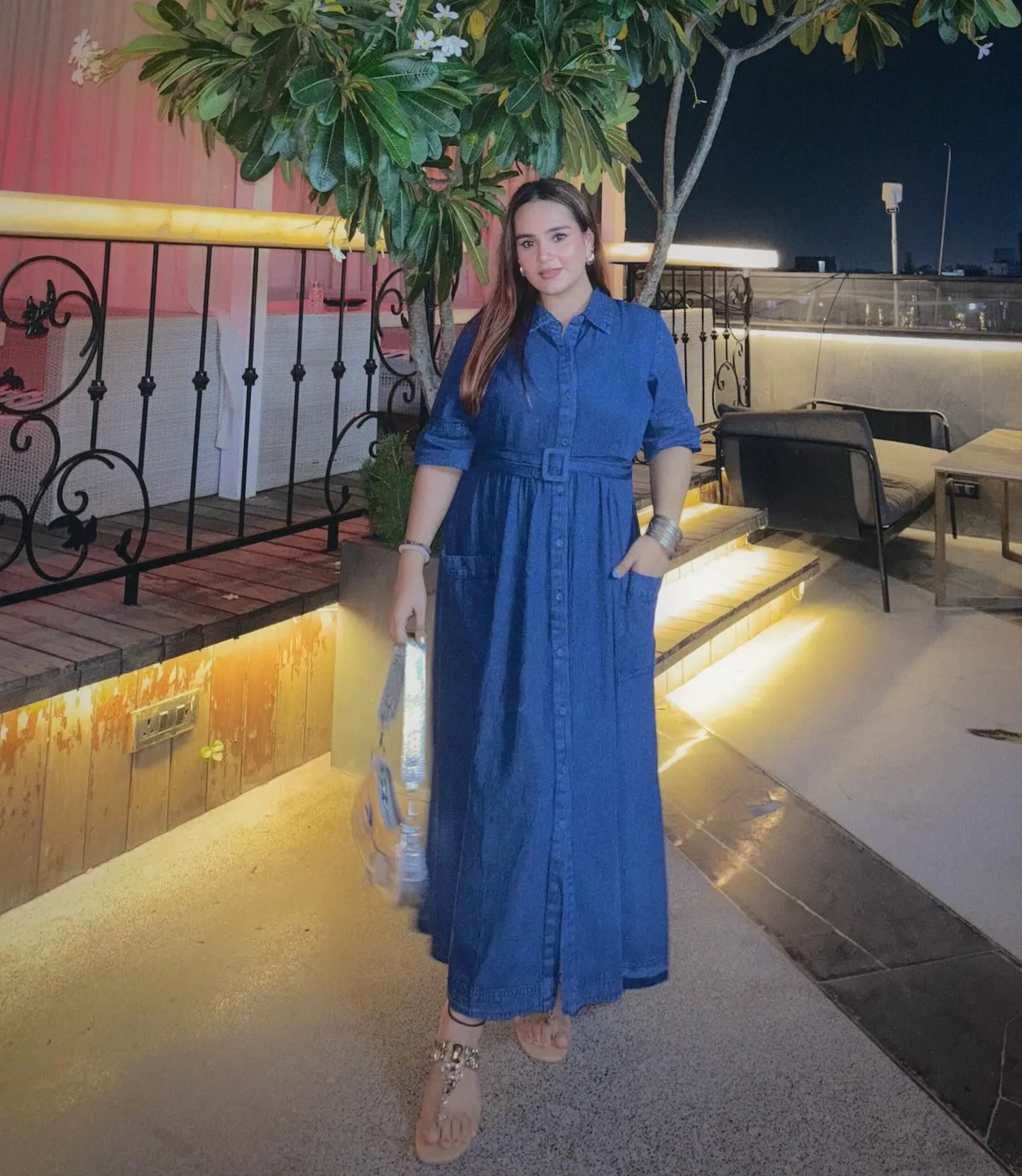 Curvy model wearing a tailored mid-wash denim wrap maxi dress designed for hourglass figures