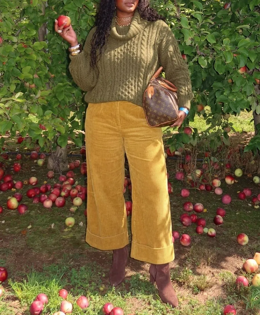 Close up detail of mustard wide leg corduroy fabric and olive green chunky knit sweater