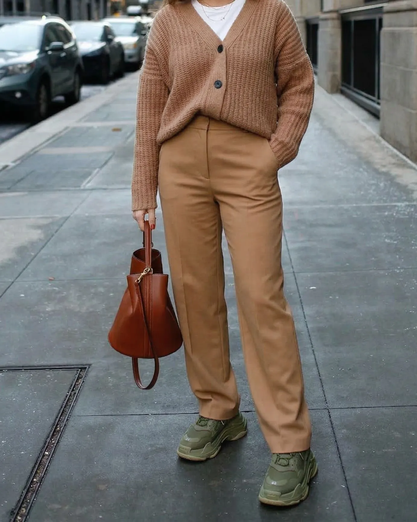 Woman wearing olive green dad sneakers with camel trousers