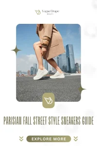 A woman wearing a camel trench coat and white leather sneakers walking on a Parisian street in fall.