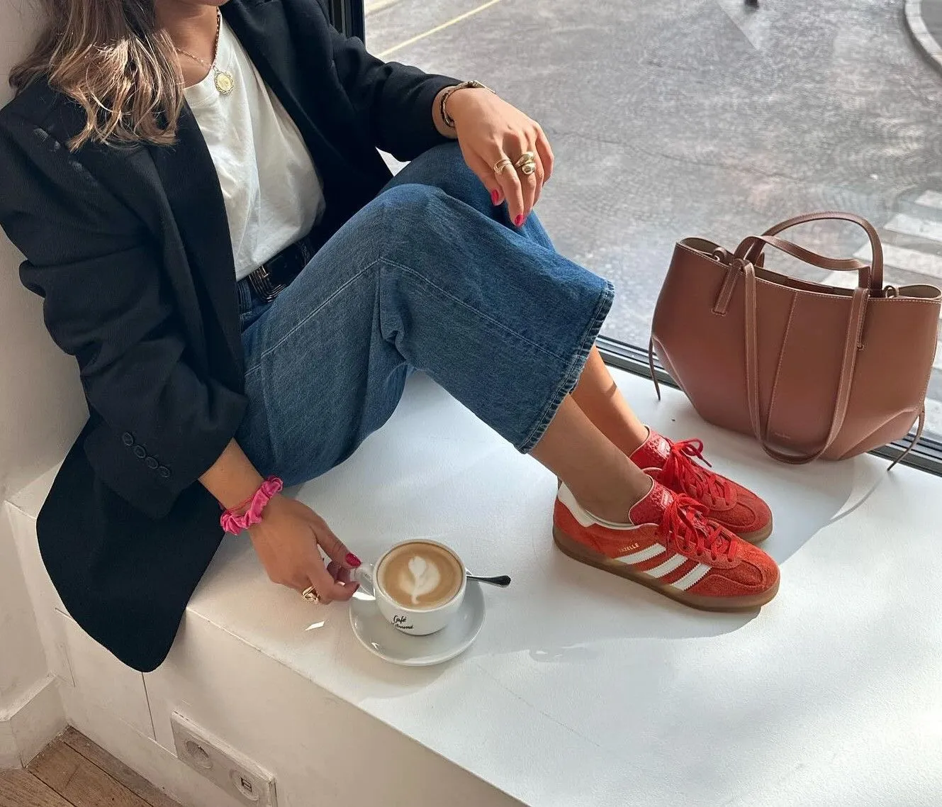 Close up of crimson red suede sneakers paired with denim and a navy blazer