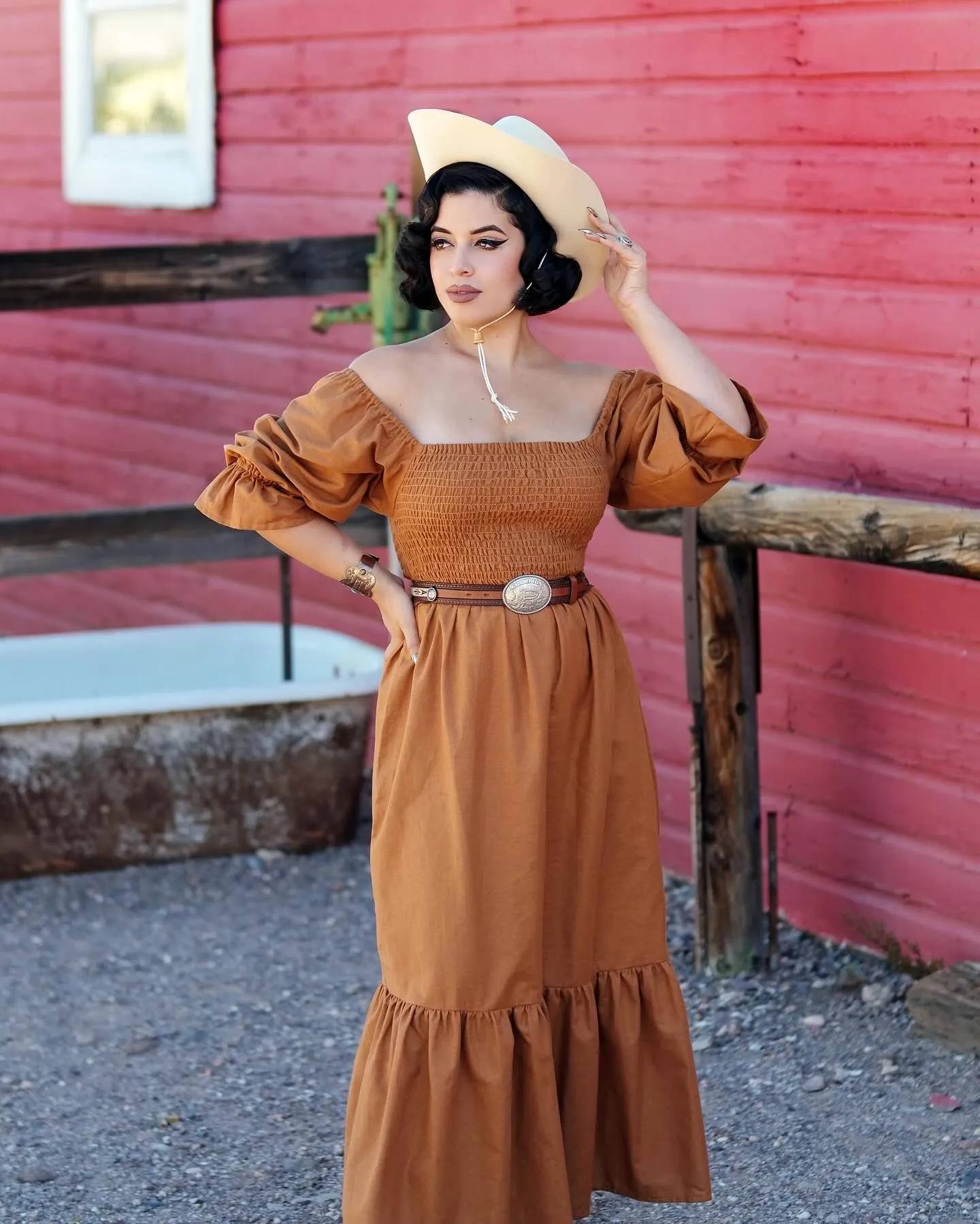 Curvy model wearing a rust smocked bodice prairie maxi dress with a tiered skirt