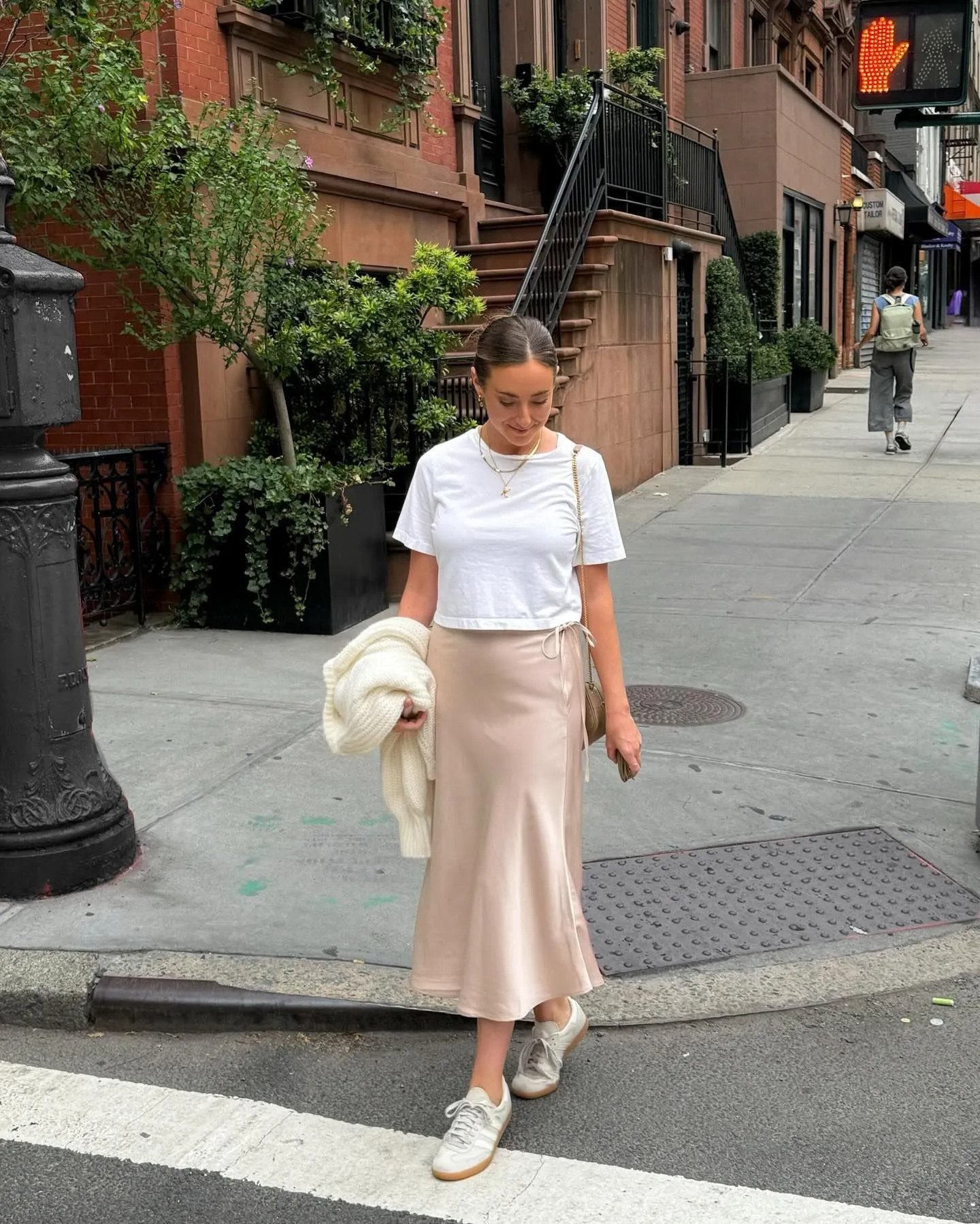 Woman in New York wearing a champagne silk skirt and white linen t-shirt