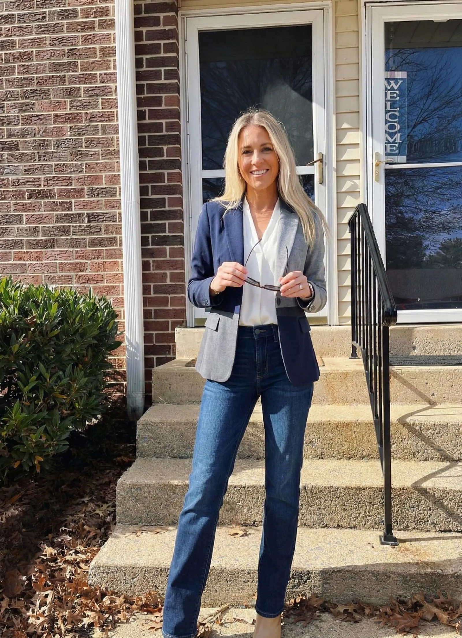Woman over 40 wearing color blocked blazer and jeans at football game