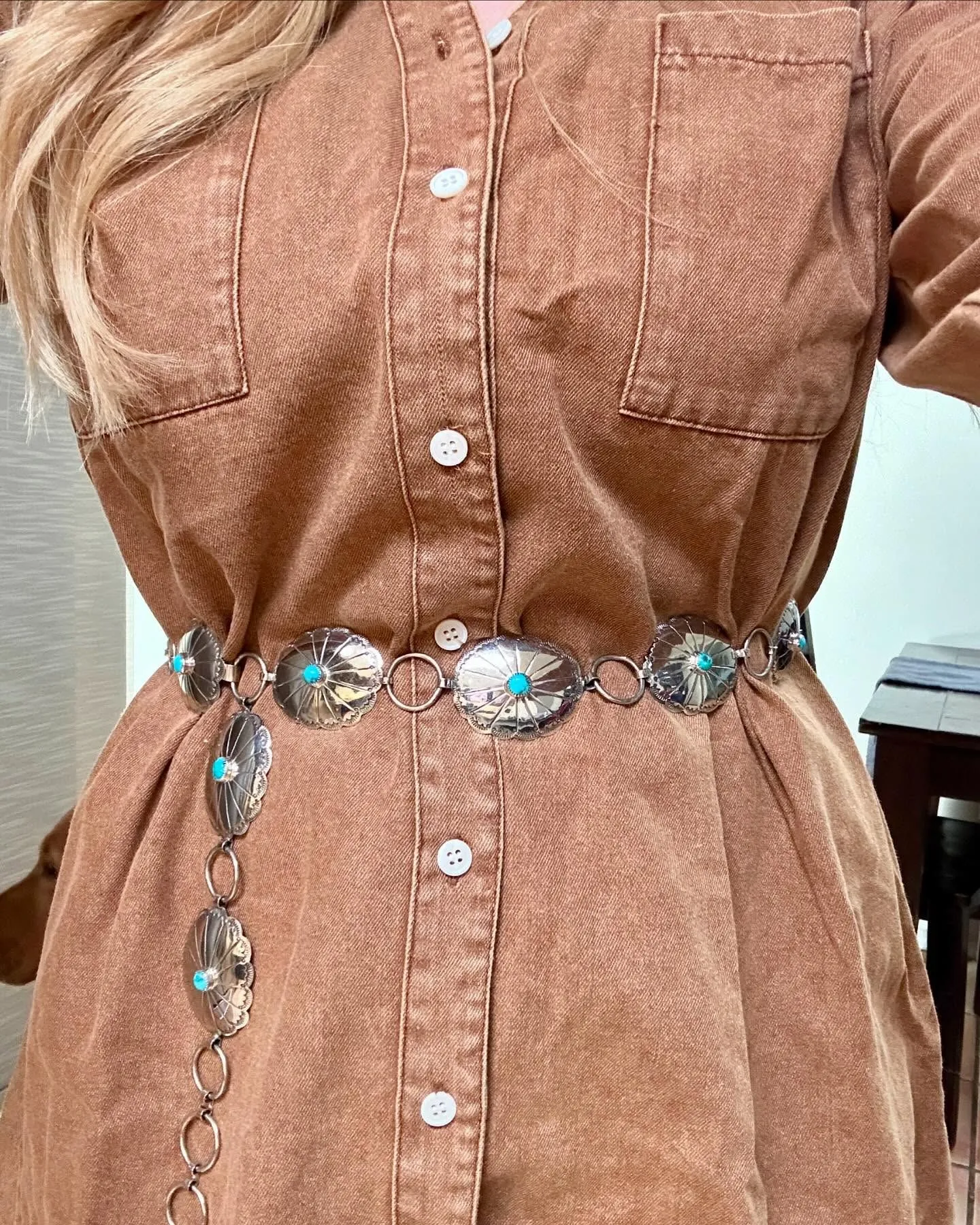 Detail shot of turquoise accessories styled with a denim western dress