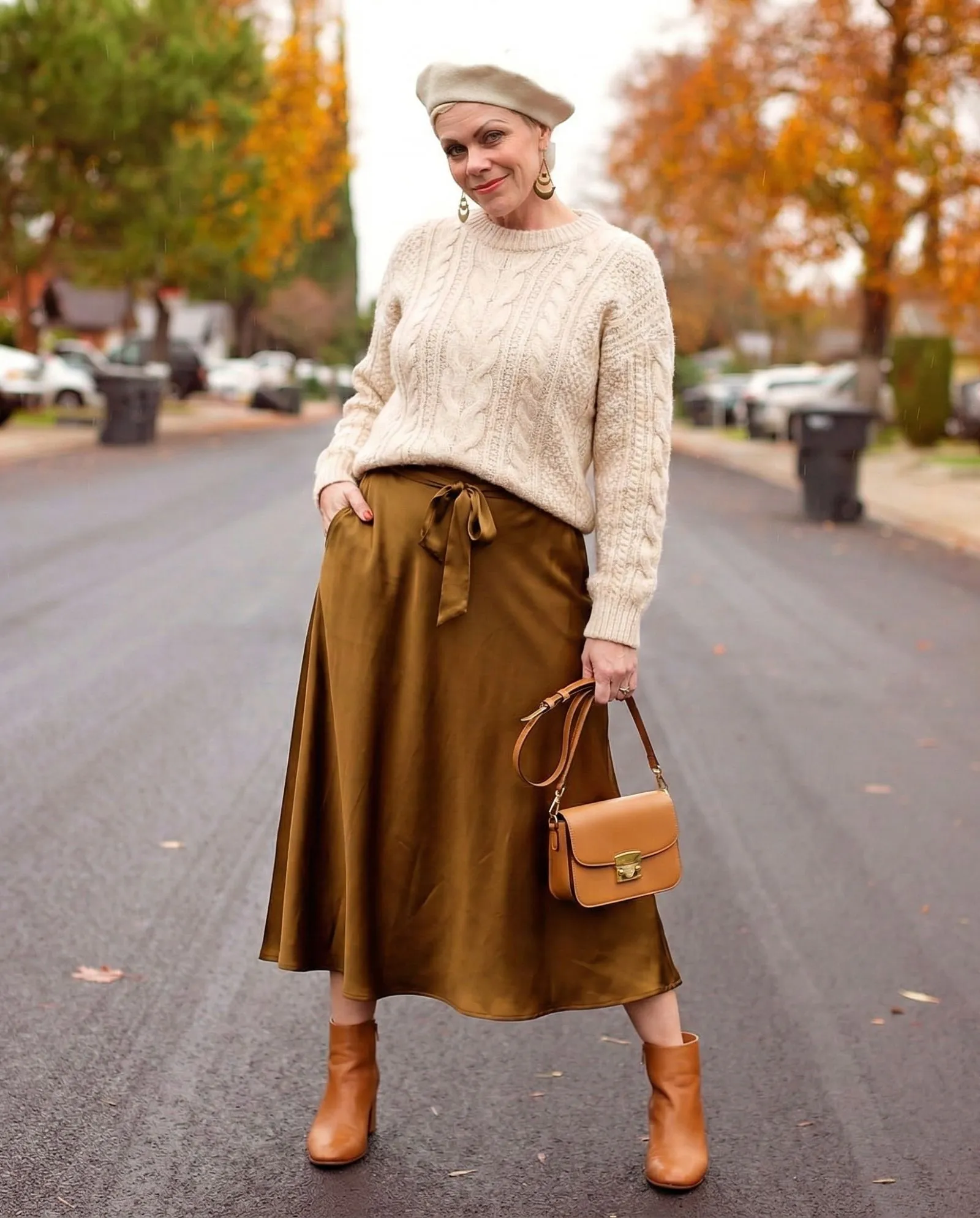 Cream knit sweater styled with silk skirt for fall game day outfit