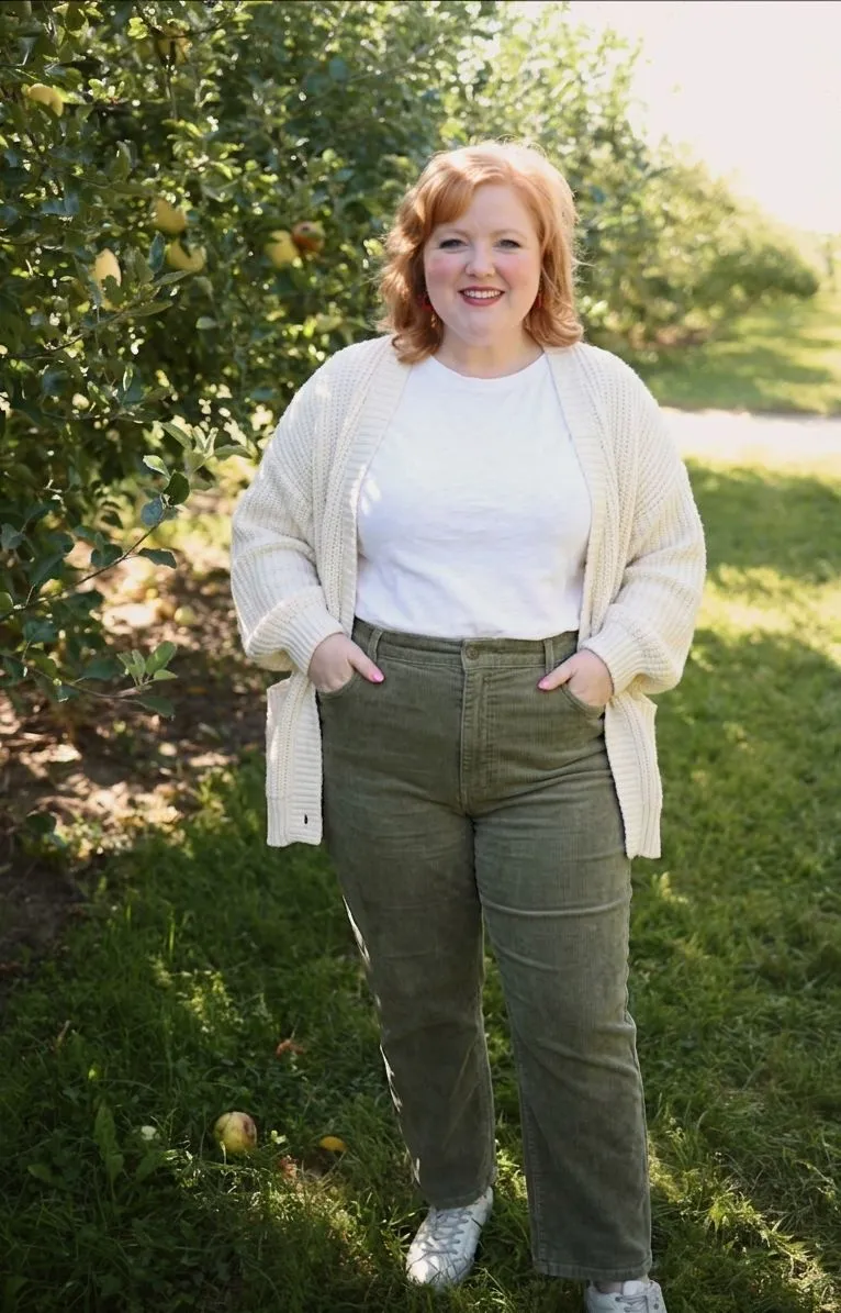 Curvy woman styling vintage wash olive corduroy pants with an open oversized cardigan