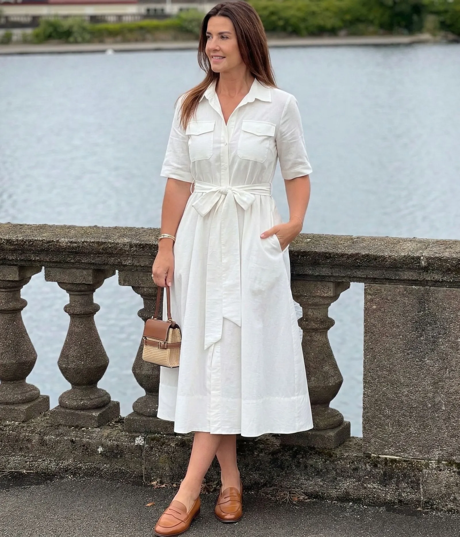 Woman in white cotton shirtdress and tan leather loafers walking in New York City