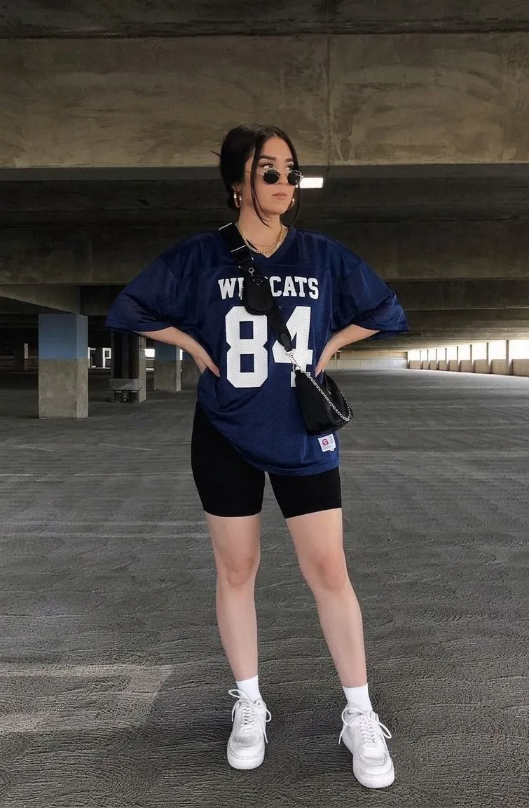 Woman in navy oversized jersey and black biker shorts for baseball date